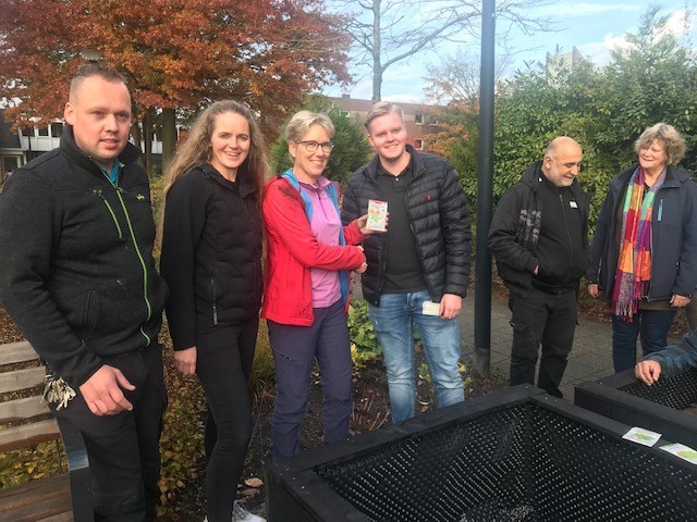 Jeanette Andries van Groeigrond overhandigt de plantenbakken en zakjes met zaden aan Henk Zantingh van Holdert